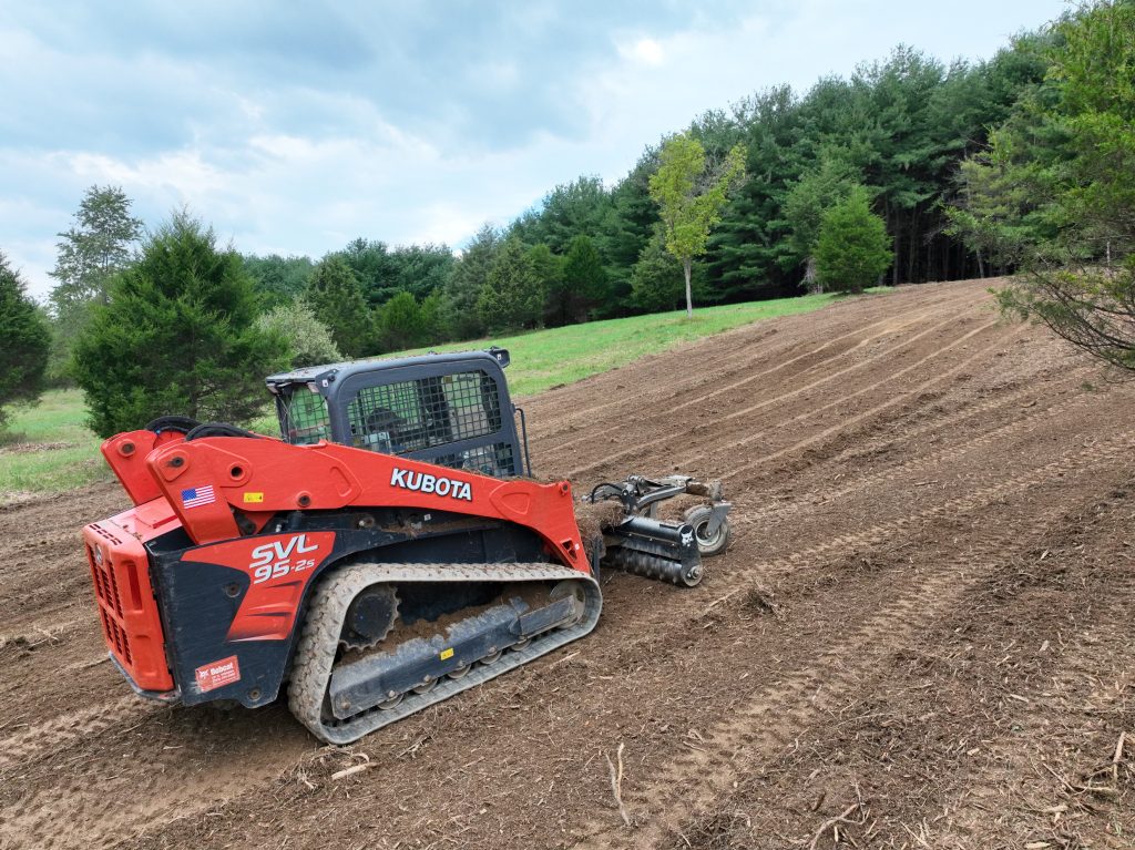 Kubota skid steer grading land.